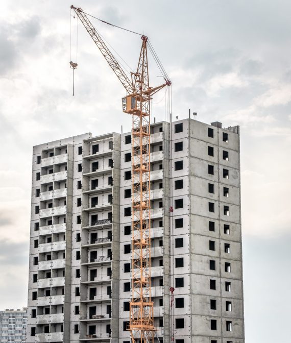 Construction site with cranes on silhouette background.